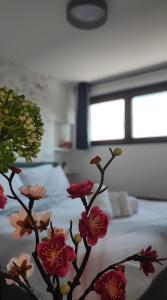 a vase filled with flowers in front of a bed at Attico Stella Alpina in Terminillo