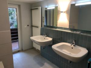 Baño con 2 lavabos y espejo en Blaues Zimmer mit grossem Balkon & Bad nur 16 km nach Würzburg!, en Mainstockheim