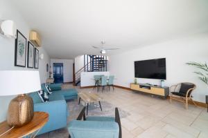 a living room with blue furniture and a flat screen tv at Jasmin in Puerto Calero
