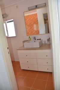 uma casa de banho com um lavatório e um espelho em Casa Linda da Praia do Alfamar em Albufeira