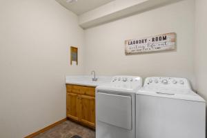 コー・ダレーンにあるMountain Home in Coeur d’ Aleneのキッチン(白い家電製品2台、シンク付)