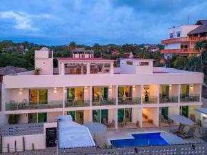 a large white building with a swimming pool at PETRAS HOTEL in Brisas de Zicatela