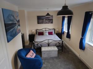 a bedroom with a bed and a blue chair at Family friendly home near Alton Towers in Stoke on Trent