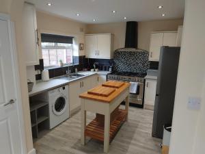 a kitchen with a sink and a stove top oven at Family friendly home near Alton Towers in Stoke on Trent