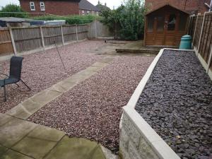 a garden with rocks and a chair and a fence at Family friendly home near Alton Towers in Stoke on Trent