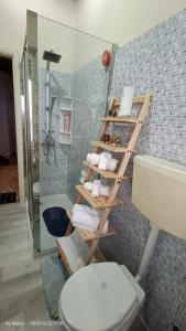 Baño con escalera de toallas junto a un aseo en Casa Vacanze da Emanuela, en Darfo
