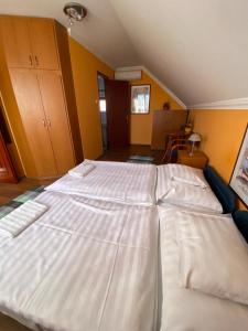 ein großes Bett in einem Zimmer mit gelben Wänden in der Unterkunft Apartman Dóra in Hajdúszoboszló