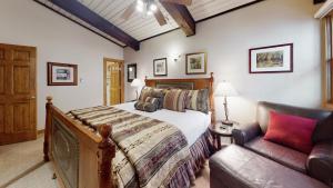 um quarto com uma cama e um sofá em Top of the Village - CoralTree Residence Collection em Snowmass Village