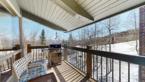 a screened in porch with a grill and snow covered trees at Top of the Village - CoralTree Residence Collection in Snowmass Village