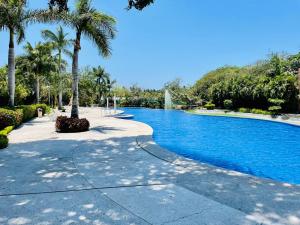 une piscine entourée de palmiers dans un parc dans l'établissement Your Luxury Oasis at Tahéima, à Nuevo Vallarta