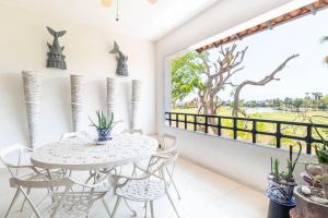 comedor con mesa, sillas y ventana en Your Luxury Oasis at Tahéima en Nuevo Vallarta 