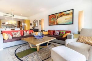 ein Wohnzimmer mit einem Sofa und einem Tisch in der Unterkunft Your Luxury Oasis at Tahéima in Nuevo Vallarta