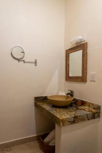 La salle de bains est pourvue d'un lavabo et d'un miroir sur un comptoir. dans l'établissement PETRAS HOTEL, à Brisas de Zicatela