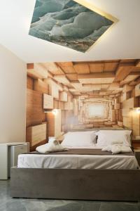 una camera da letto con un grande letto e un dipinto sul muro di Napolitano Rooms (Central Station) a Napoli