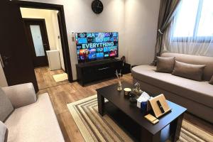 a living room with a couch and a tv at شقة فندقية فاخرة بحي الروضة in Jeddah