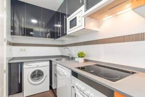 a kitchen with a sink and a washing machine at JA Suites Madrid in Madrid