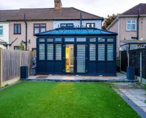 un hangar bleu dans l'arrière-cour d'une maison dans l'établissement UPPAMOST LUXURY HOME LONDOn, à Dagenham