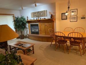 salon ze stołem, krzesłami i kominkiem w obiekcie 2 Bedroom Condo - Blackfoot 313 w mieście Driggs
