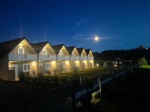 a row of houses at night with the moon in the sky at Westbeach House in Grzybowo