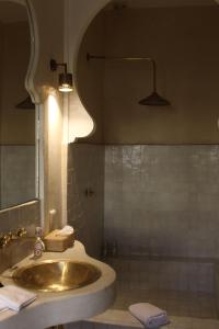 une salle de bain avec un lavabo et un miroir dans l'établissement Riad Emberiza Sahari, à Marrakech 79 autres photos
