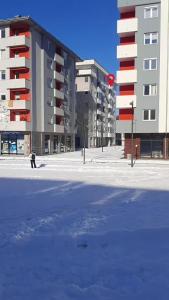a person walking in the snow in front of a building at Apartman Pale - Biljana in Pale