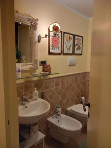 a bathroom with two sinks and a toilet at Linda's Holiday Home in Roccastrada