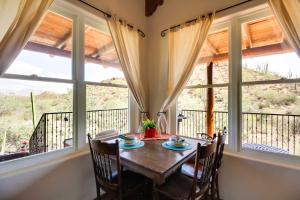 una sala da pranzo con tavolo, sedie e finestre di El Diamante Mtn-View Casita with Private Jacuzzi! a Tucson Altre 26 foto