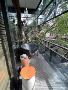 uma varanda com uma banheira preta e uma mesa em Brick Hotel Mexico City - Small Luxury Hotels of the World em Cidade do México