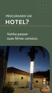 a hotel with a palm tree in front of a building at HOTEL VEREDAS in Monsenhor Paulo