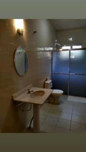 ein Badezimmer mit einem Waschbecken, einem WC und einem Spiegel in der Unterkunft HOTEL VEREDAS in Monsenhor Paulo