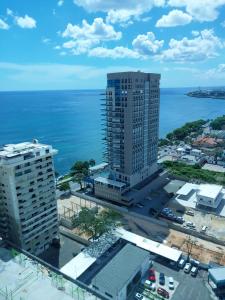 z góry widok na wysoki budynek nad oceanem w obiekcie Habitacion privada en apartamento compartido w mieście Santo Domingo