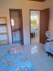 Habitación con cama y baño con lavabo. en Casa Relva Suítes en Lençóis