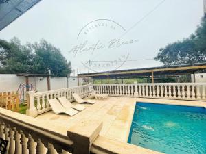 - une piscine avec des chaises longues et un panneau indiquant l'happy blalee dans l'établissement Cabañas Atlantic Breeze, à Mar del Plata