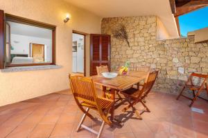 a dining room with a wooden table and chairs at Villa Vittoria - Costa Paradiso in Costa Paradiso