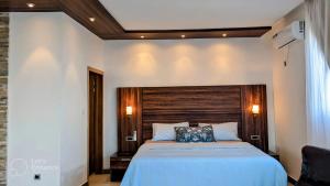 a bedroom with a large bed with a wooden headboard at Toilcam in Buea