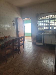 cocina con mesa y sillas en una habitación en Um oásis a 50 metros da praia, en Mongaguá