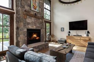 uma sala de estar com uma grande lareira de pedra em Month long Rental- Teton Springs Home, 4 Bedroom em Victor