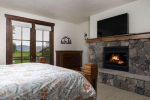 um quarto com uma lareira, uma cama e uma televisão em Month long Rental- Teton Springs Home, 4 Bedroom em Victor