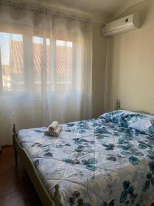 um quarto com uma cama e uma janela com cortinas em Caminho da Vila moradia. em Escalos de Cima