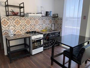 a kitchen with a stove and a table with a dining table at Mar Del Castle in Mar del Plata