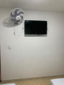 pared blanca con TV y ventilador en Hotel La Fresa en Pereira
