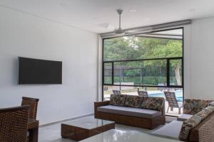 Casa Campestre Ensueño في ريكورت: غرفة معيشة مع أريكة وتلفزيون بشاشة مسطحة