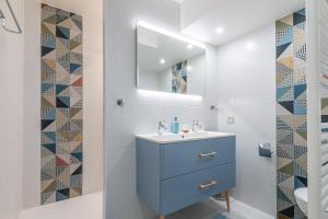 a bathroom with a blue cabinet and a mirror at PENTHOUSE Luxe DISNEYLAND PARIS in Chessy