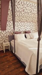 a bedroom with a bed with a black and white wallpaper at Villa Westfalia Guest House in Târgu Secuiesc