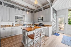 a kitchen with white cabinets and a table and chairs at The Roller Coaster River Retreat in Tampa