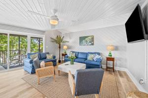 a living room with blue couches and a tv at The Roller Coaster River Retreat in Tampa