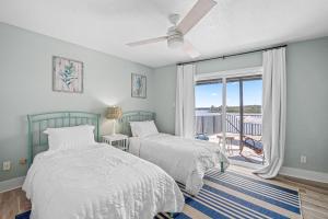 two beds in a bedroom with a balcony at The Roller Coaster River Retreat in Tampa