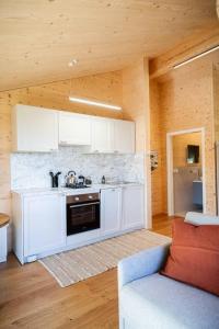 a kitchen with white cabinets and a stove at Appartement Mondholzliebe DG in Argenbühl