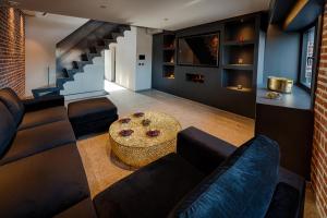 a living room with a couch and a table at AGORA Tournai - Wellness Suites in Tournai