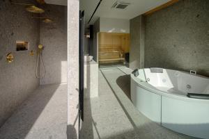 two pictures of a bathroom with a bath tub at AGORA Tournai - Wellness Suites in Tournai